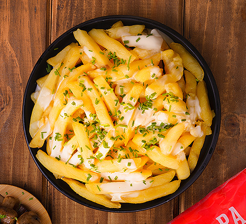 Papas fritas con queso, crema ácida y ciboulette